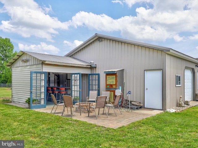 rear view of house featuring a fire pit, a patio area, and a lawn