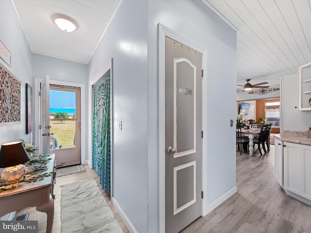 corridor with light hardwood / wood-style flooring and wood ceiling