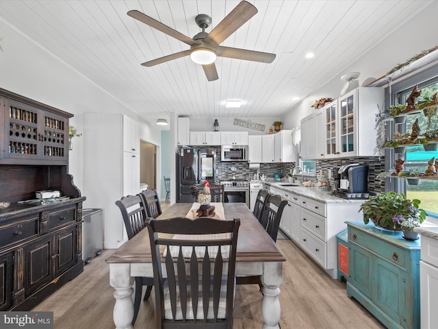 dining area featuring ceiling fan, light wood-type flooring, sink, and wooden ceiling