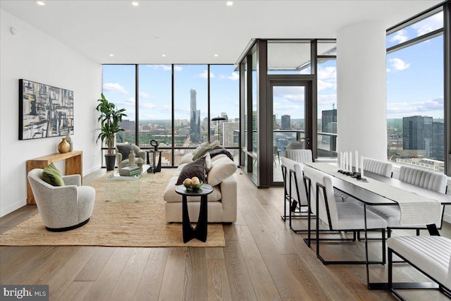 living room featuring floor to ceiling windows, plenty of natural light, and hardwood / wood-style flooring