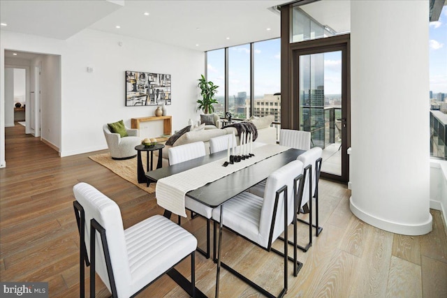 dining space featuring expansive windows and hardwood / wood-style flooring