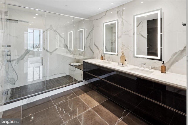 bathroom featuring tile flooring, vanity with extensive cabinet space, double sink, and a shower with shower door