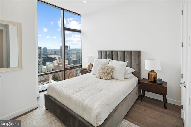 bedroom featuring floor to ceiling windows and wood-type flooring