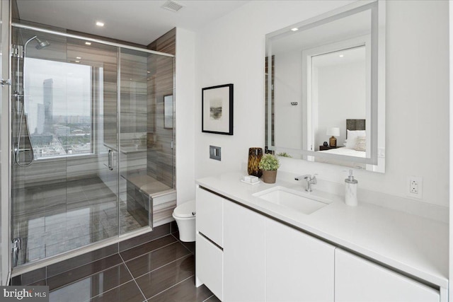 bathroom with an enclosed shower, vanity, toilet, and tile flooring