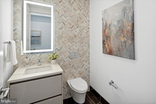 bathroom with backsplash, vanity, tile floors, and toilet