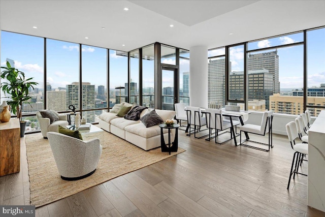 living room with plenty of natural light, expansive windows, and hardwood / wood-style floors