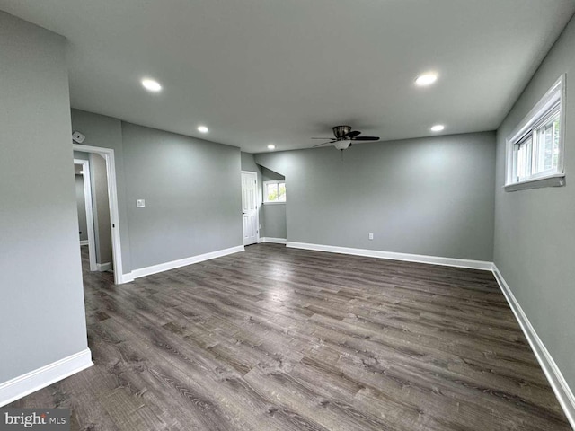 spare room featuring a healthy amount of sunlight, ceiling fan, and dark hardwood / wood-style floors