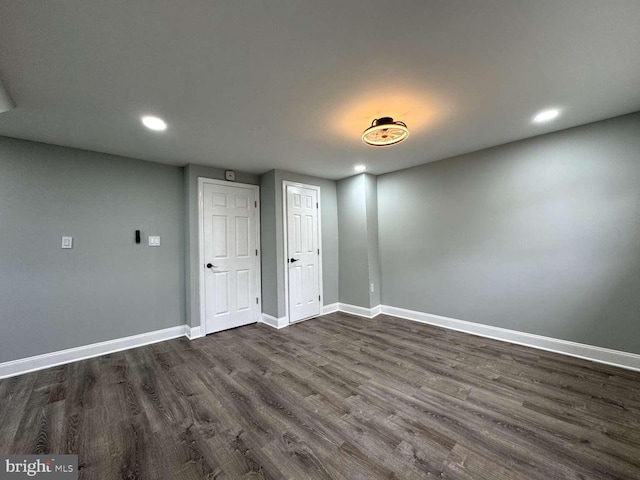 unfurnished room with dark wood-type flooring