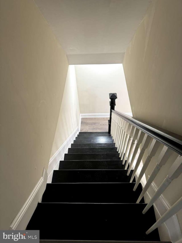 stairway featuring dark wood-type flooring