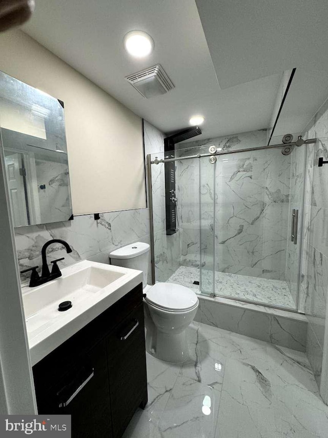 bathroom featuring tile walls, a shower with door, toilet, tile flooring, and vanity