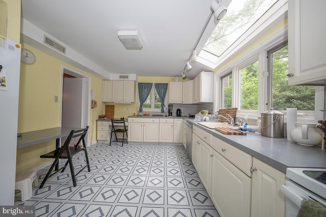 kitchen with a skylight, plenty of natural light, white range, and track lighting