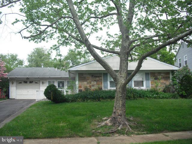 ranch-style home with a garage and a front lawn