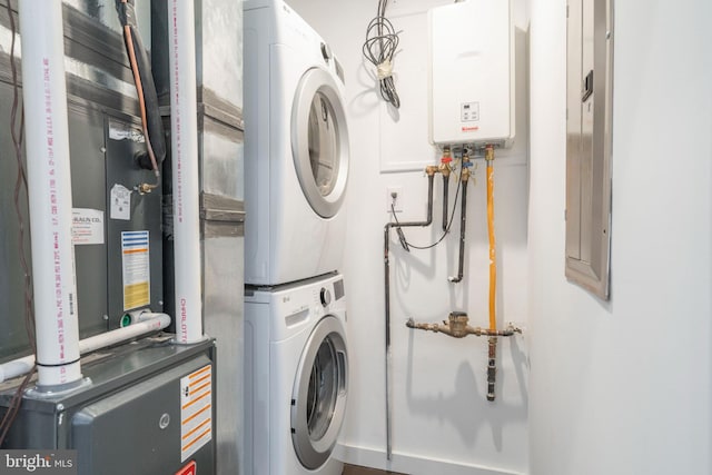 laundry room with stacked washer / drying machine and tankless water heater