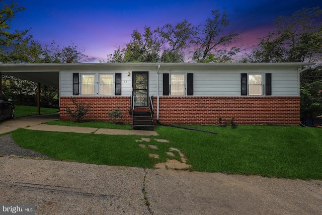 view of front of home with a yard and a carport