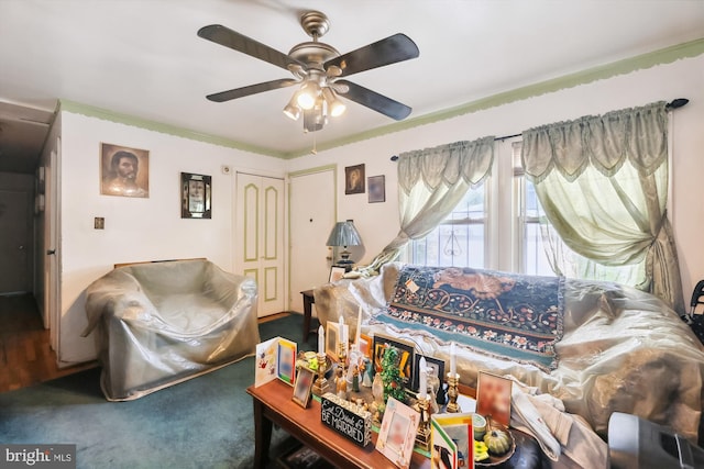 living room featuring dark colored carpet and ceiling fan