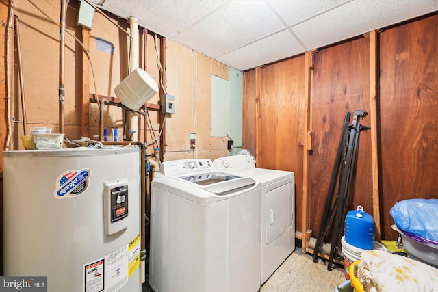 washroom with washing machine and dryer, light tile floors, and electric water heater