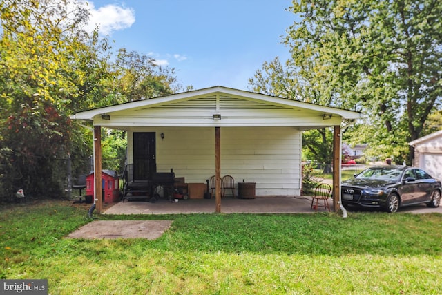 rear view of property featuring a lawn and a carport