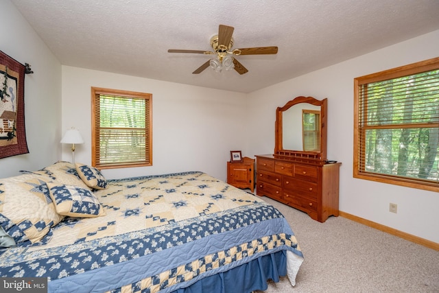 bedroom featuring a textured ceiling, ceiling fan, and carpet flooring