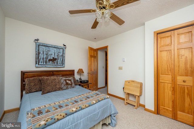 carpeted bedroom with a closet, ceiling fan, and a textured ceiling