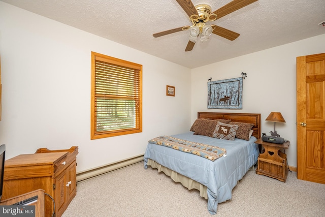 carpeted bedroom with baseboard heating, ceiling fan, and a textured ceiling