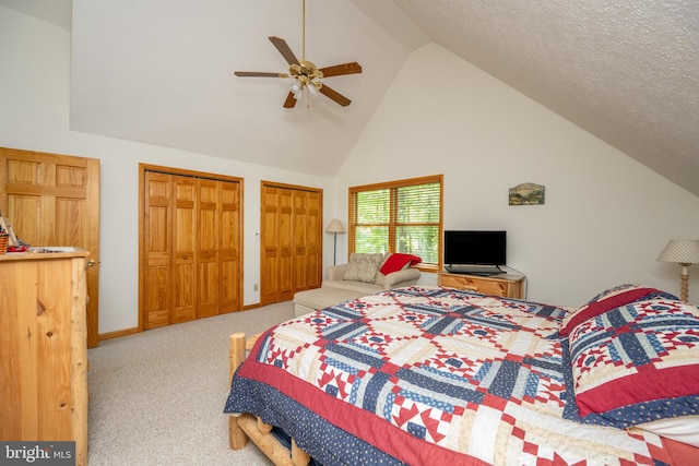 bedroom featuring ceiling fan, multiple closets, light carpet, high vaulted ceiling, and a textured ceiling