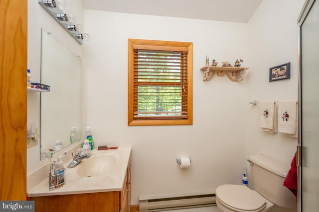 bathroom with a baseboard radiator, large vanity, toilet, and a textured ceiling