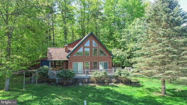 back of house featuring a deck and a lawn