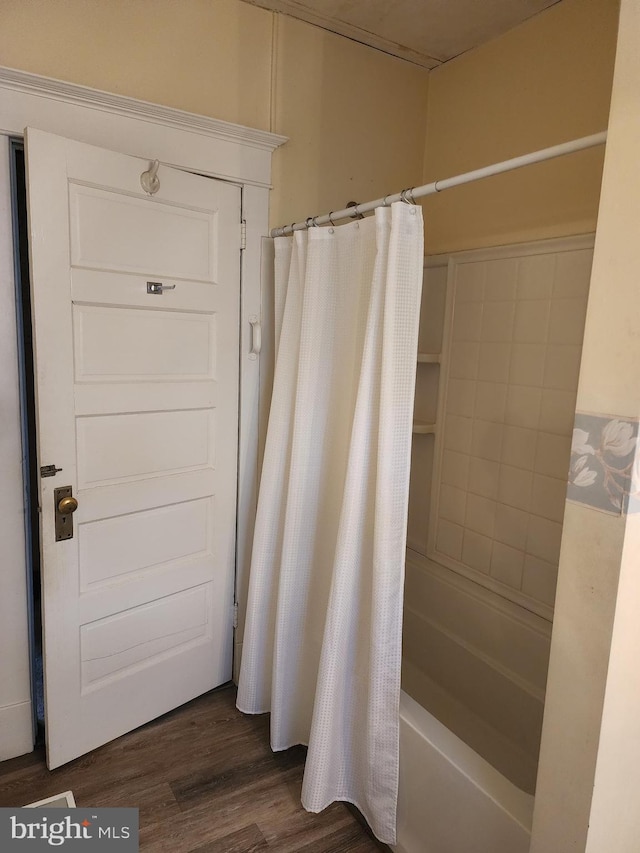 bathroom featuring hardwood / wood-style flooring and shower / tub combo