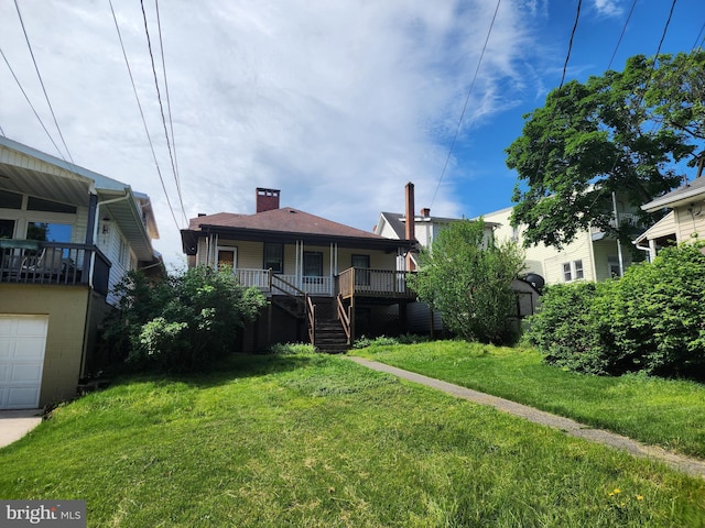 view of front of property with covered porch, a garage, and a front lawn