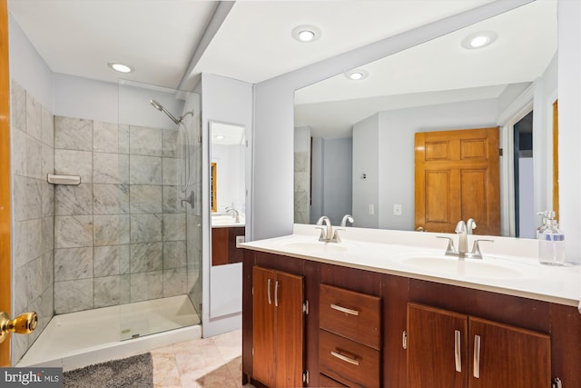 bathroom featuring tile patterned floors, vanity, and a tile shower