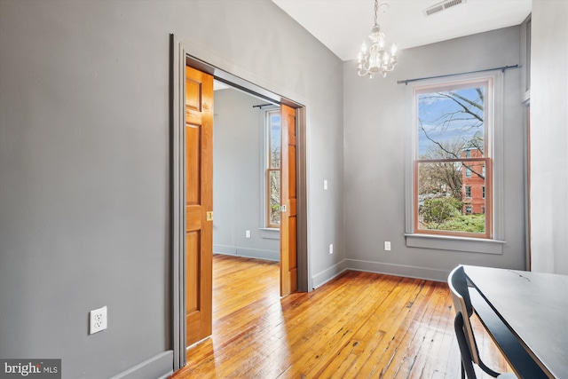 interior space featuring light hardwood / wood-style flooring and a notable chandelier