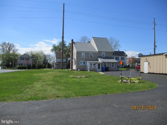 view of front facade featuring an outbuilding and a front lawn