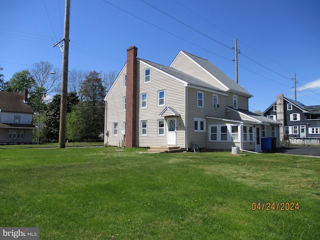 rear view of property featuring a lawn