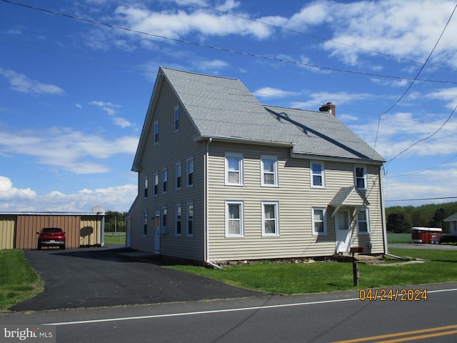 view of side of property with a yard, an outdoor structure, and a garage