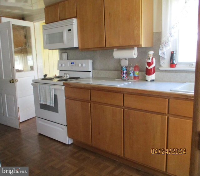 kitchen with dark parquet flooring, white appliances, tasteful backsplash, and sink