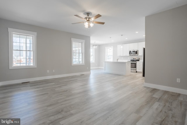 unfurnished living room featuring ceiling fan and light hardwood / wood-style floors