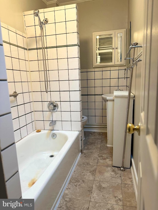 bathroom featuring tiled shower / bath, tile flooring, toilet, and tile walls