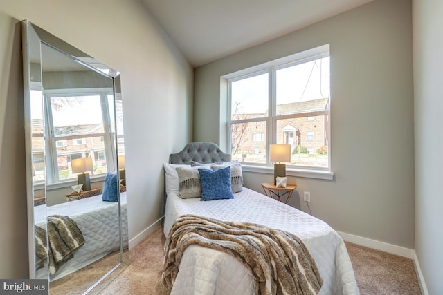 bedroom featuring carpet flooring, vaulted ceiling, and multiple windows