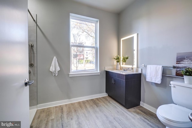 bathroom featuring a wealth of natural light, wood-type flooring, vanity, and toilet