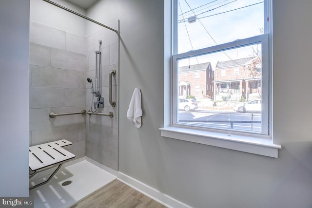 bathroom featuring a tile shower and wood-type flooring