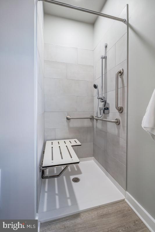 bathroom featuring tiled shower and hardwood / wood-style flooring