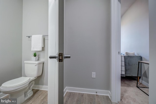 bathroom with toilet and hardwood / wood-style floors