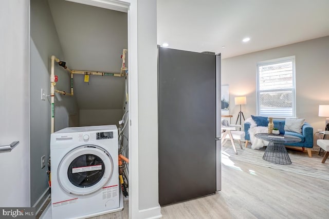 laundry room with washer / dryer and light wood-type flooring