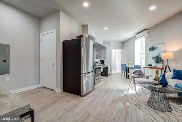 kitchen featuring stainless steel appliances, light hardwood / wood-style floors, and a wall mounted air conditioner