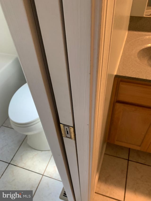 bathroom featuring tile patterned floors, vanity, and toilet