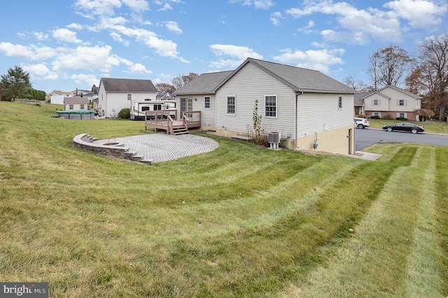 back of house with a deck, cooling unit, a patio area, and a lawn