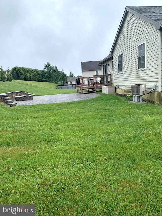 view of yard featuring cooling unit and a wooden deck