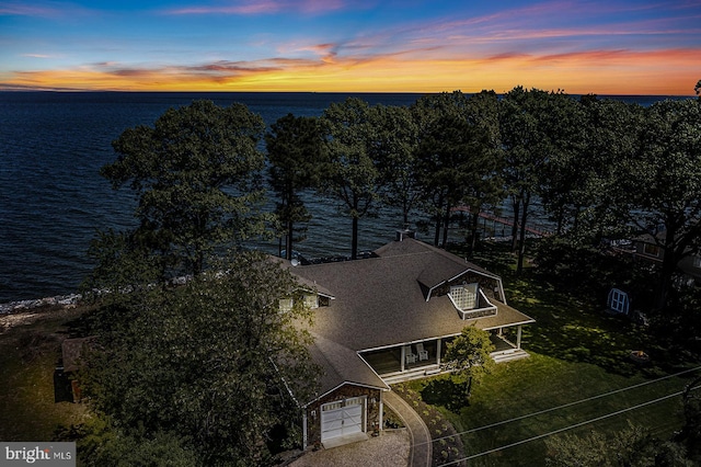 aerial view at dusk featuring a water view