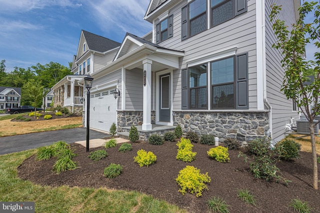 view of front of property featuring central AC, a garage, and a porch