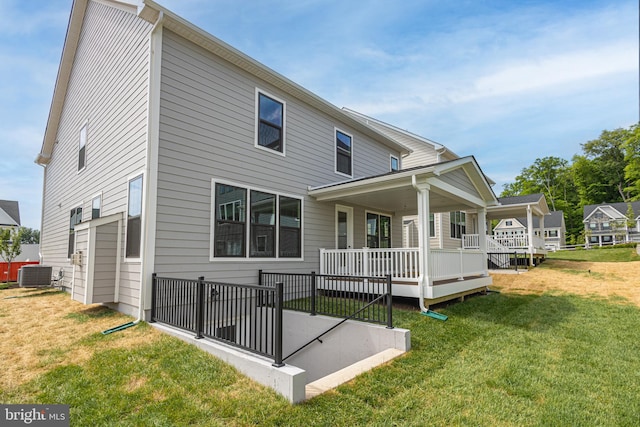 back of property with a yard and central AC